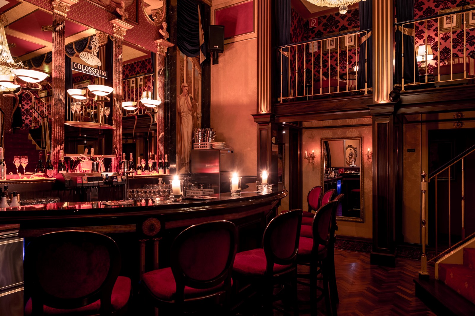 Die VIP-Bar im 1. Stock: Galerie mit goldenem Geländer, Samtstühle und Kerzenlicht.