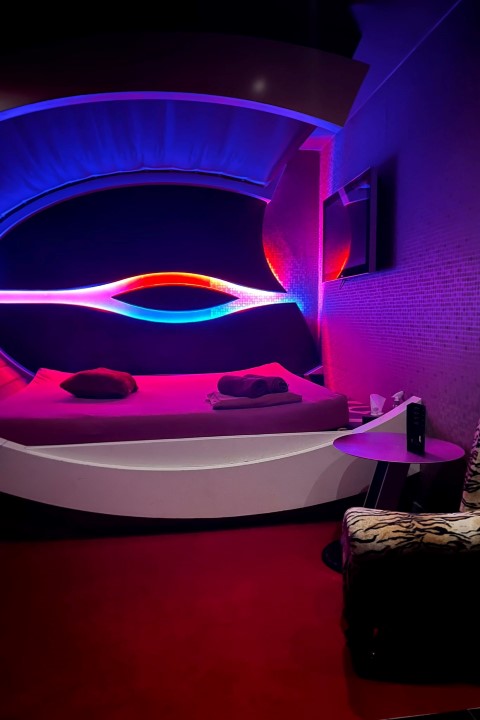 Atmosphere Lounge: ovale Bettnische mit blau-rotem Lichtband.