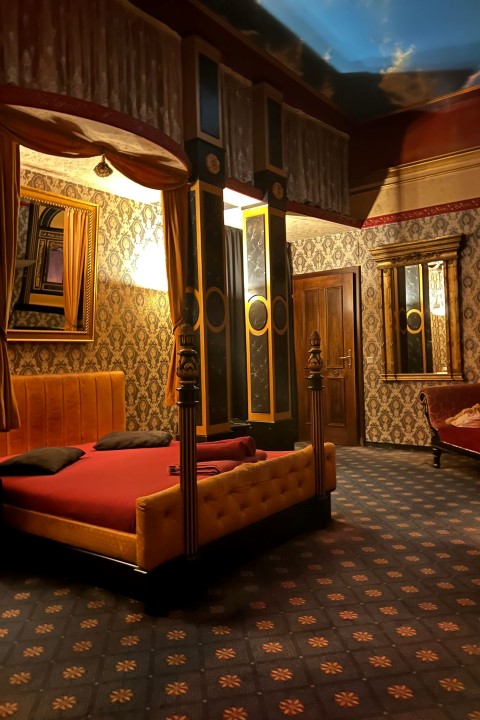 Classic Roman Suite: Himmelbett vor Ornamenttapete, gemalter Himmel an der Decke.
