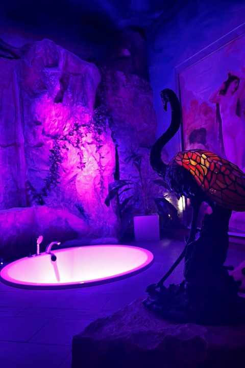 Imperial Whirlpool Suite: Grotte mit Whirlpool in blau-violettem Licht.