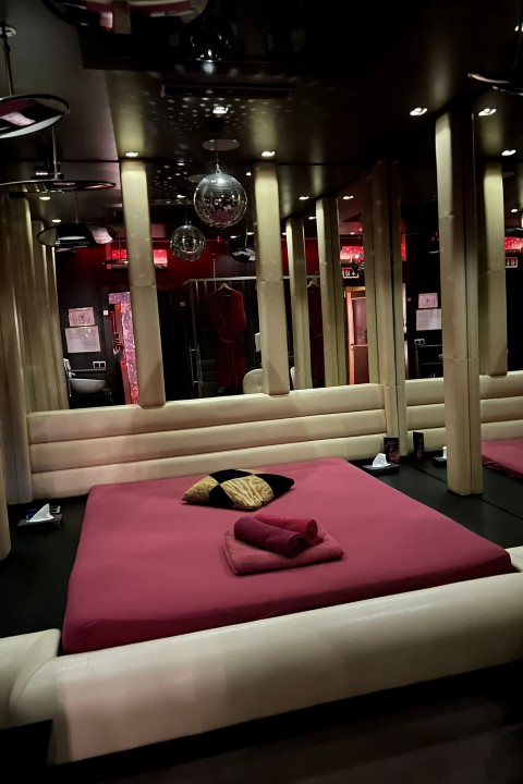 Spiegel Suite: Bett vor einer Spiegelwand, darüber Discokugeln.